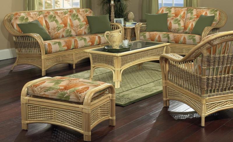 A tropical-themed living room set featuring natural rattan furniture, including a sofa, chairs, and a coffee table, with floral cushions and a matching ottoman. Ideal for cozy interiors