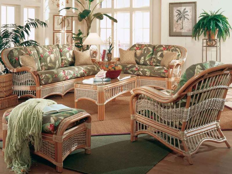 A tropical-themed living room set featuring rattan furniture with floral-patterned cushions, matching a coffee table and an ottoman. Bright, airy, and perfect for creating a relaxing space